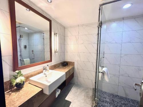 a bathroom with a sink and a shower at Yitel Collection Lianyungang High-speed Railway Station Suning Plaza in Lianyungang