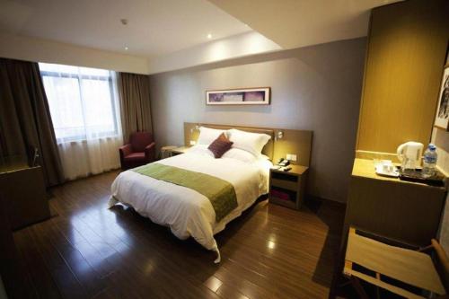 a hotel room with a bed and a chair at Yitel Collection Lianyungang High-speed Railway Station Suning Plaza in Lianyungang