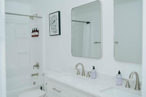 a white bathroom with a sink and a mirror at 5040 Sqft l Sleeps 25 l Near Ski & Downtown SLC in West Jordan