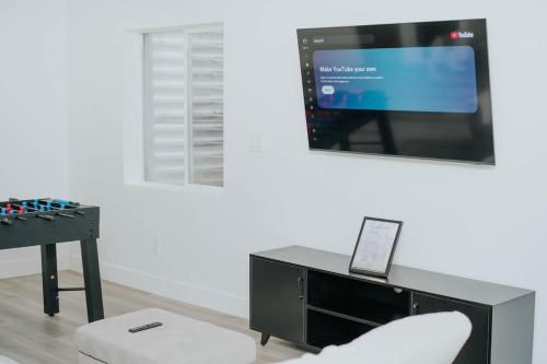 a living room with a tv and a chair and a table at 5040 Sqft l Sleeps 25 l Near Ski & Downtown SLC in West Jordan