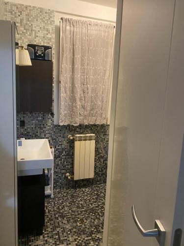 a bathroom with a sink and a shower curtain at Grazioso monolocale con giardino in Pregnana Milanese