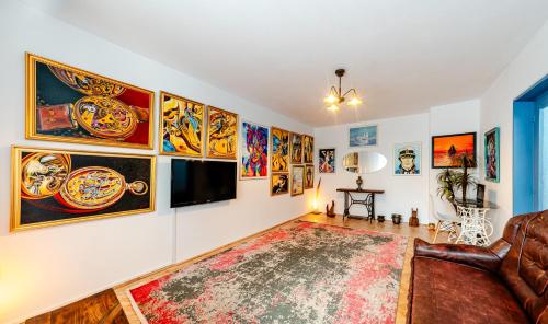 un salon avec un canapé et une télévision fixée au mur dans l'établissement Central Art Apartment with Treasure Hunt, Free Parking & Self Check-In, à Constanţa