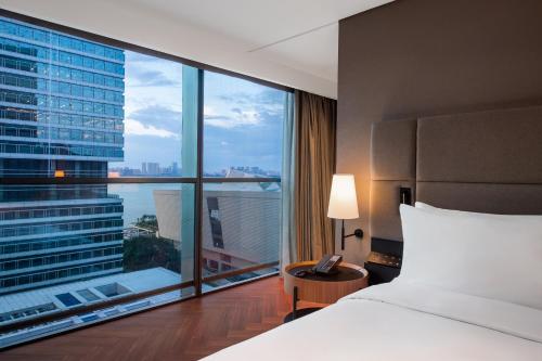 a hotel room with a bed and a large window at Intercity Hotel Shantou CHJ in Shantou