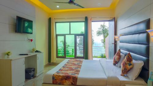 a bedroom with a large bed and a large window at Pacific Inn Mussoorie in Mussoorie
