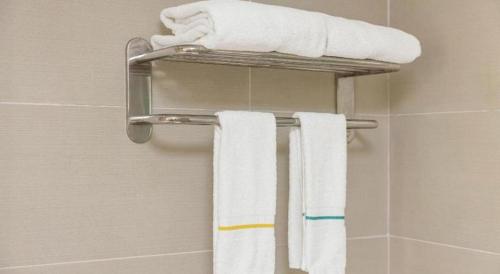 a towel rack in a bathroom with towels on it at City Comfort Inn Wuhan High Speed Railway Station in Wuhan