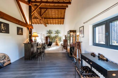 a living room with wooden floors and a large window at Le Palmier Exotique in Bazas