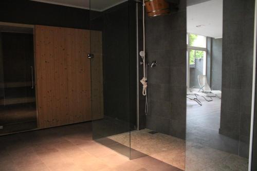 a glass shower with a door in a room at Colle del Giglio Resort & Spa in Ripatransone