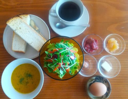 a table with plates of food and a cup of coffee at こだまやリトリート 女性専用 Kodamaya Retreat Women-Only in Matsumoto