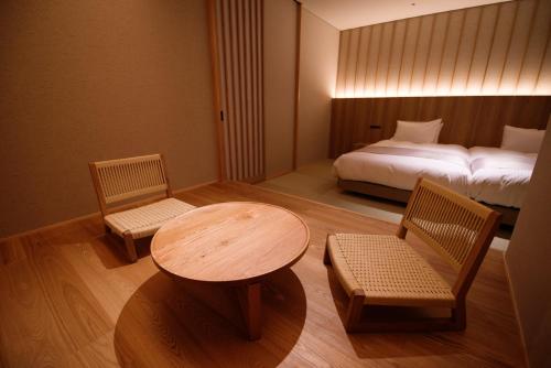 a room with a table and two chairs and a bed at 山人 Oga in Oga