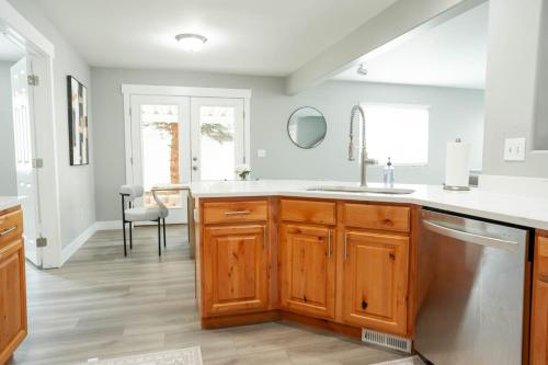 a kitchen with wooden cabinets and a sink at 3240 Sqft Family-Friendly Retreat l Salt Lake Area in West Jordan