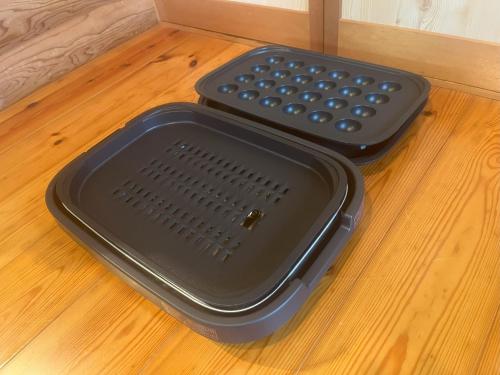 two black containers sitting on a wooden floor at 天然温泉露天風呂付コテージ山樹荘 in Hita