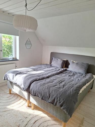 a bedroom with a large bed in a white room at Mysigt stenhus i Simrishamn in Simrishamn