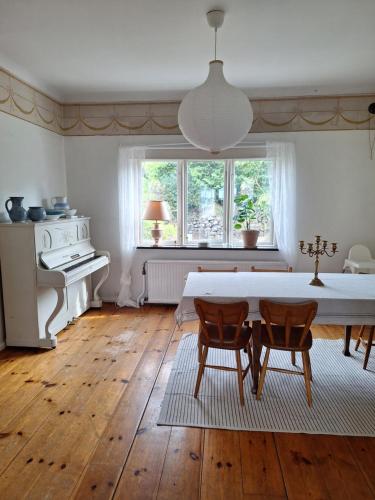 Una sala de estar con una mesa y sillas y una ventana. en Mysigt stenhus i Simrishamn, en Simrishamn