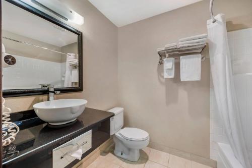 a bathroom with a sink and a toilet and a mirror at Quality Inn Umatilla - Hermiston in Umatilla
