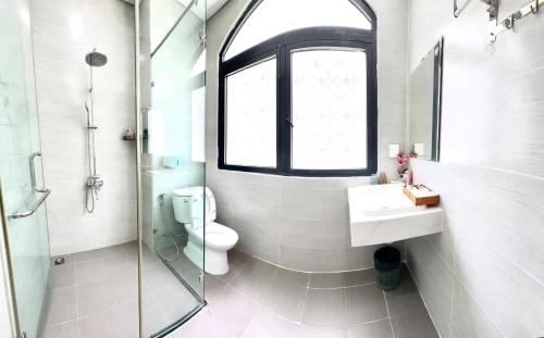 a bathroom with a toilet and a sink and a window at Moc Lam Homestay GrandWorld Phu Quoc in Phu Quoc