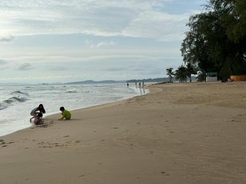 two people playing in the sand on the beach at Moc Lam Homestay GrandWorld Phu Quoc in Phu Quoc