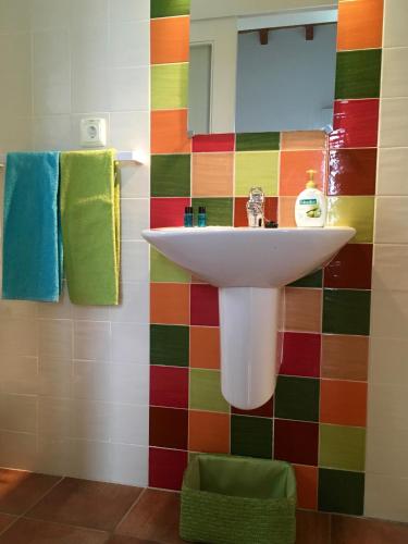 a bathroom with a sink and a colorful tiled wall at Casa Azul in Almograve