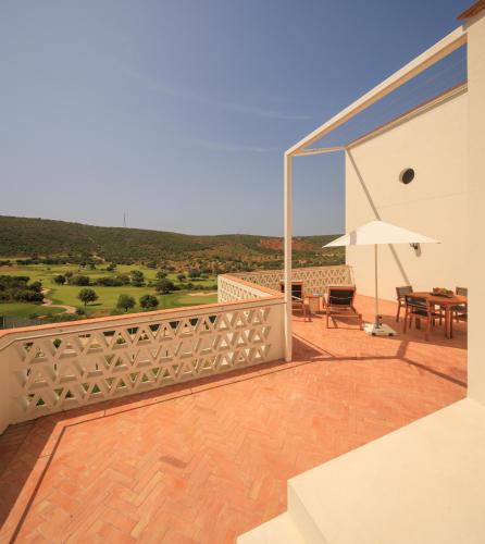 a balcony with a table and an umbrella at Viceroy at Ombria Algarve in Loulé