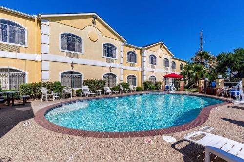 a swimming pool in front of a building at Quality Suites North Houston - Spring in Houston