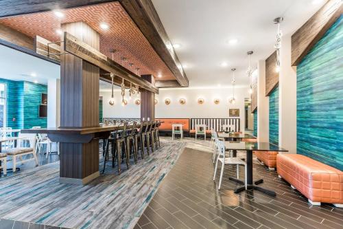 a restaurant with a bar and tables and chairs at Marina Bay Hotel & Suites, an Ascend Collection Hotel in Chincoteague