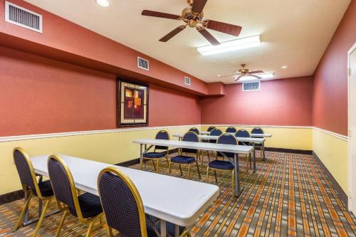 a conference room with tables and chairs and a ceiling fan at Quality Suites North Houston - Spring in Houston
