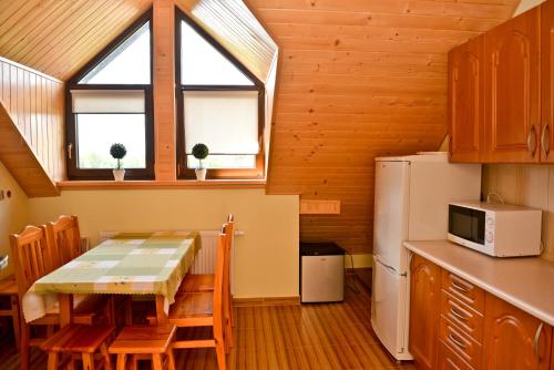 a small kitchen with a table and a refrigerator at Agroturystyka Nad Stawem in Górno