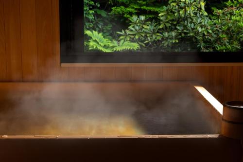 a table with smoke in front of a window at 旅庵 川喜 in Omachi