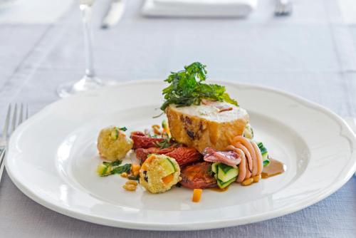 a white plate with food on a table at Kydon The Heart City Hotel in Chania Town