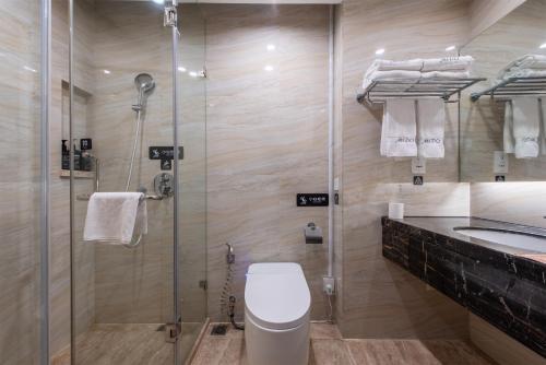 a bathroom with a shower and a toilet and a sink at Mido International Hotel in Guangzhou