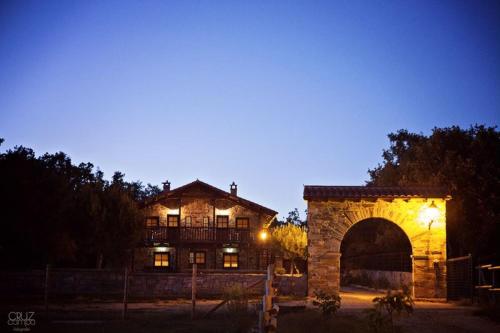 a large stone building with an archway at night at Apartamentos turísticos LAS CARBALLEDAS in Rabanal del Camino
