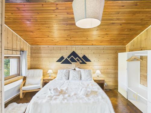 a bedroom with a bed and a wooden ceiling at Le Haut de Sauté Vue Imprenable à Bussang in Bussang