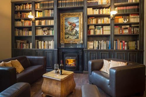 a library with two couches and a fire place at Waldschlösschen Wangen in Wangen