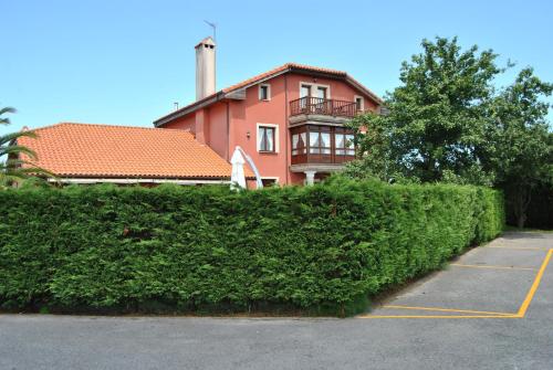 a building behind a hedge in front of a building at Posada de Suesa in Suesa