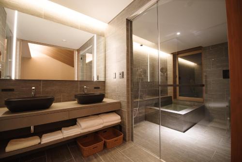 a bathroom with two sinks and a glass shower at 山人 Oga in Oga