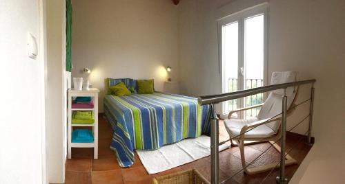 a small bedroom with a bed and a chair at Casa Azul in Almograve