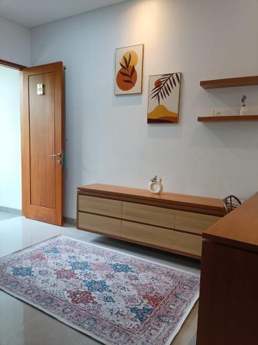 a living room with a wooden bench and a rug at Rauda Living Space Syariah in Pasuruan