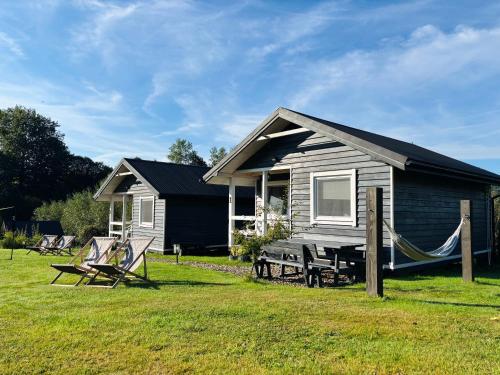 a small house with a hammock outside of it at Skandynawia in Uherce Mineralne