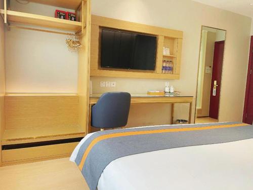 a bedroom with a bed and a desk with a television at Beijing Inner Mongolia Hotel Chaoyang in Beijing