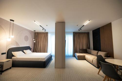 a bedroom with a bed and a couch and a table at Senior Apartment with Lake View in Eforie Nord