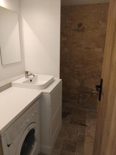une salle de bains avec lave-linge et lavabo dans l'établissement Chez Anaïs, à Cénac-et-Saint-Julien