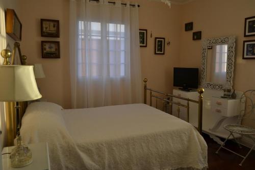ポンタ・デルガダにあるC&C Homeのベッドルーム1室(ベッド1台、窓、鏡付)