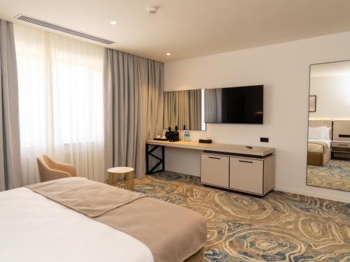 a hotel room with a bed and a desk at Shirvan Grand Hotel Shamakhi in Şamaxı