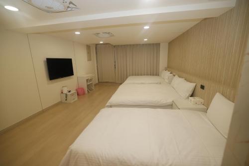 a room with two beds and a flat screen tv at Sea Keelung in Keelung