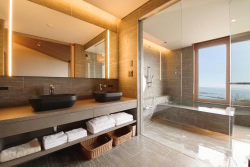 a bathroom with two sinks and a shower and a tub at 山人 Oga in Oga