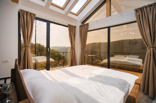 a bedroom with a bed and a large window at Cabana romantica cu cer vizibil din pat - Apuseni Air Luna in Mătişeşti