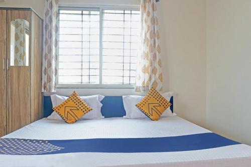 a bedroom with a bed with blue and yellow pillows at Hotel O Chalukya Executive in Phūrsungi