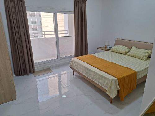 a bedroom with a bed and a large window at House of Idris Stylish 1BHK - Muscat in Muscat