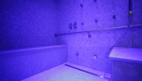 a bathroom with a tub and a shower with purple lights at Hotel Renaissance in Florence