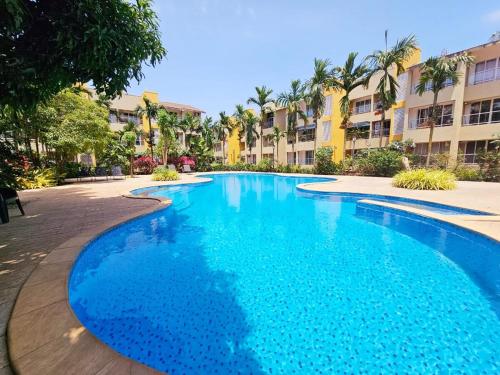 een groot blauw zwembad in een resort bij Spacious Condo with Pool View in Anjuna