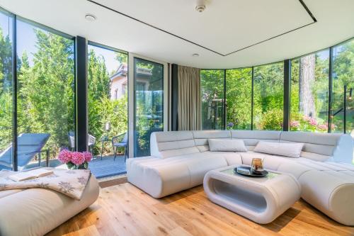 a living room with white furniture and large windows at Strandhaus in Bansin